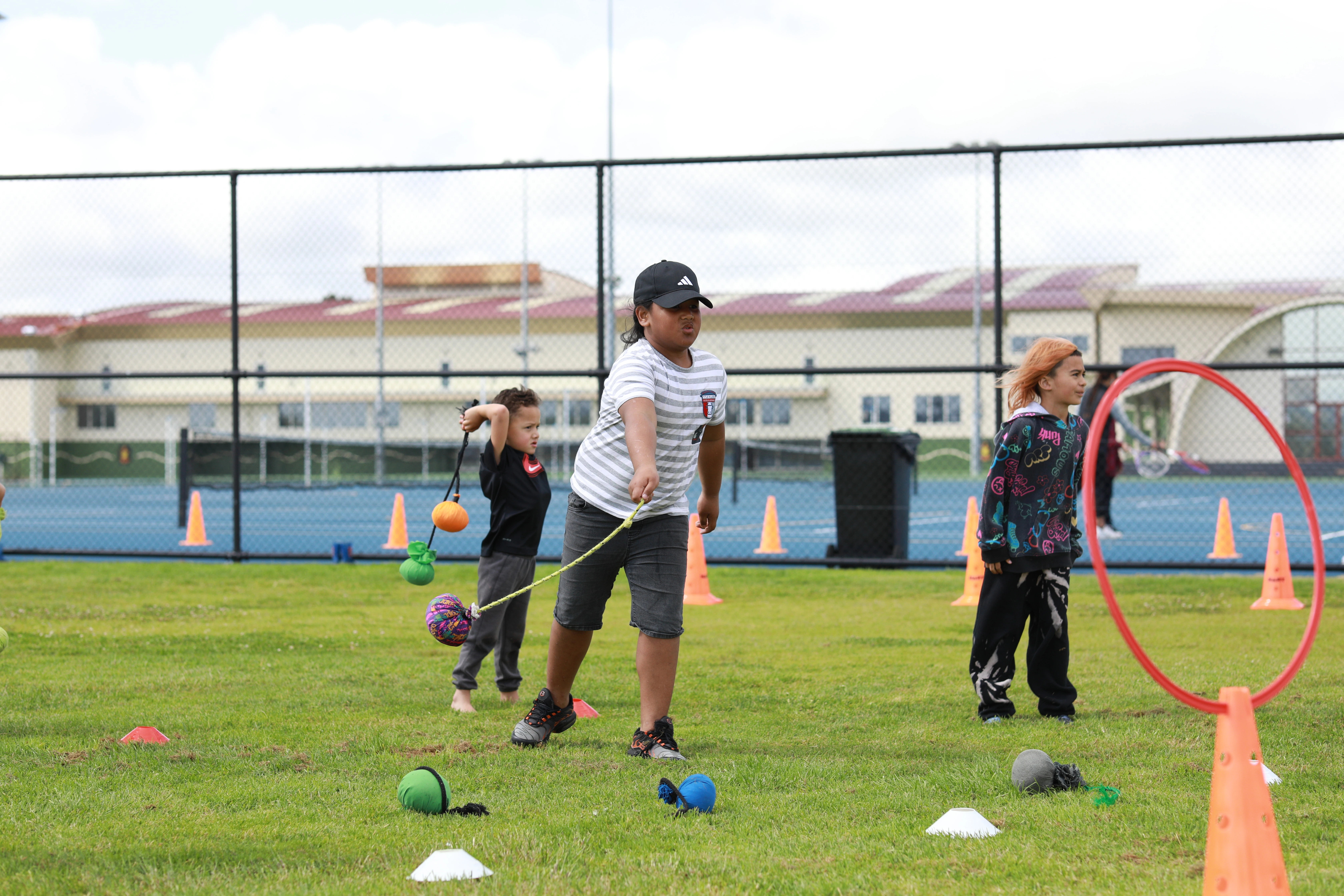 Māori children playing sport on a grass field